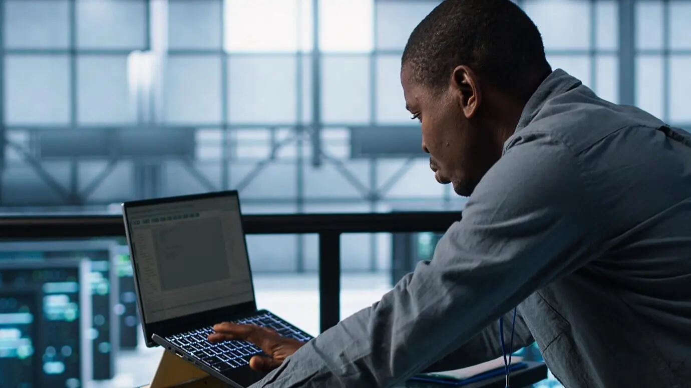 Techniker im Rechenzentrum, der Programmiersprachen auf einem Laptop verwendet.